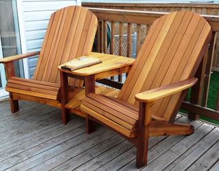 Pair of cedar Adirondack chairs joined by a small table on a wooden deck